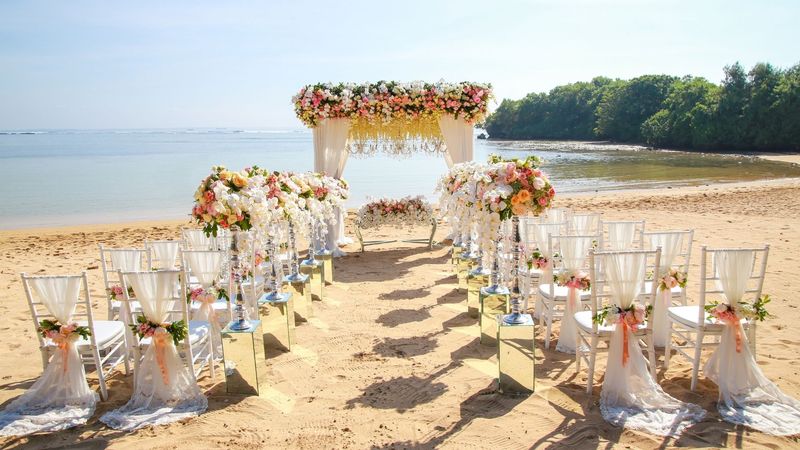 Ceremonia en playa con arco y sillas vestidas